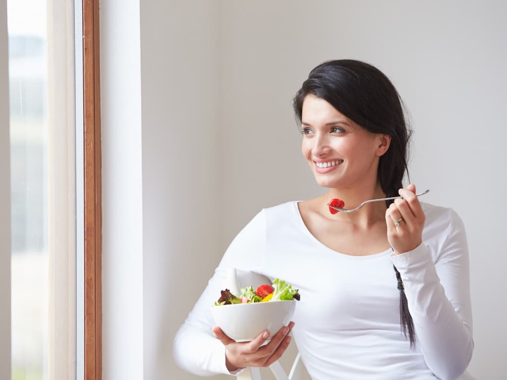 Woman eating fruit from a bowl