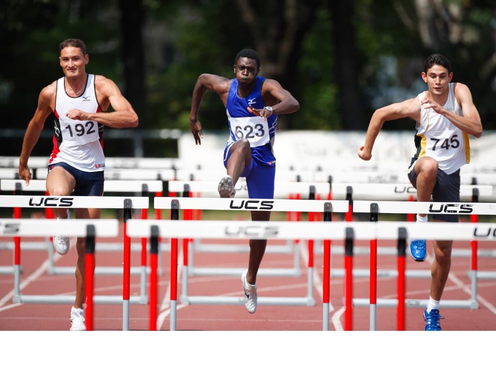 Sprinters running hurdles