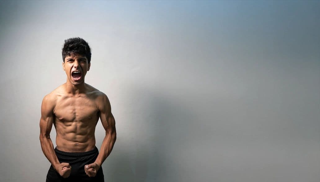 A pexels.com image of a ripped shirtless boy sad and angry