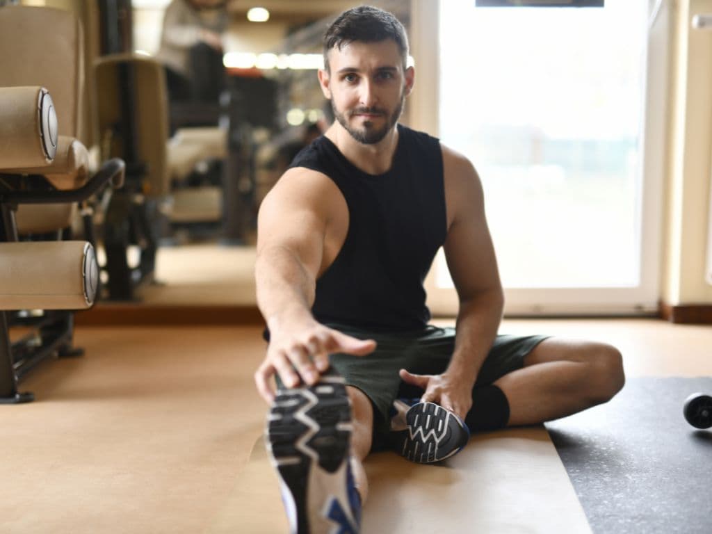 A man sitting on the floor doing yoga or stretches