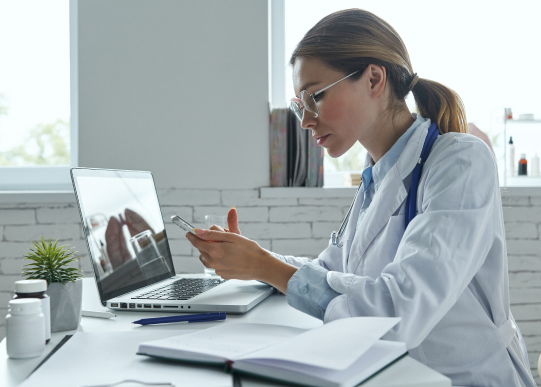 confident-female-doctor-using-smart-phone