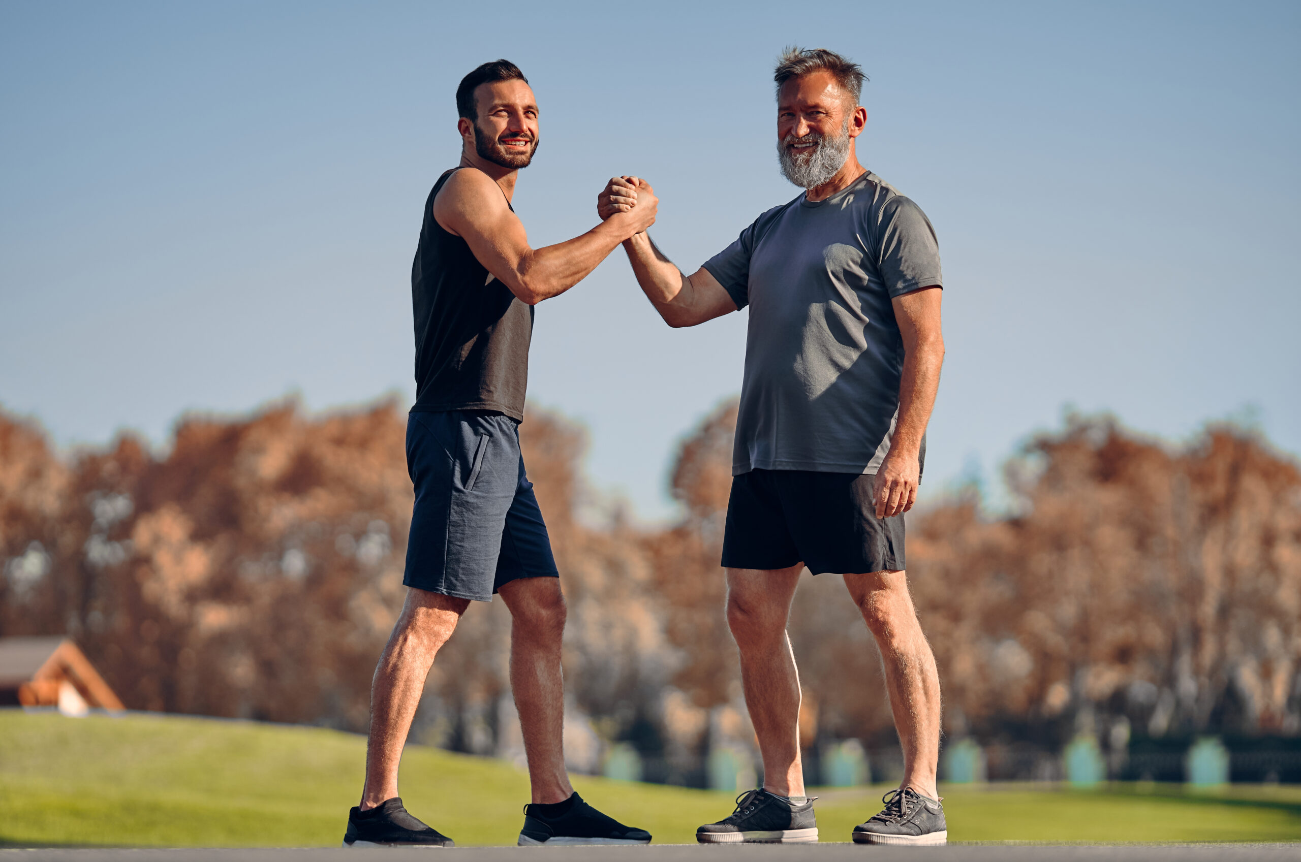 The young and old athletes greeting in the beautiful park