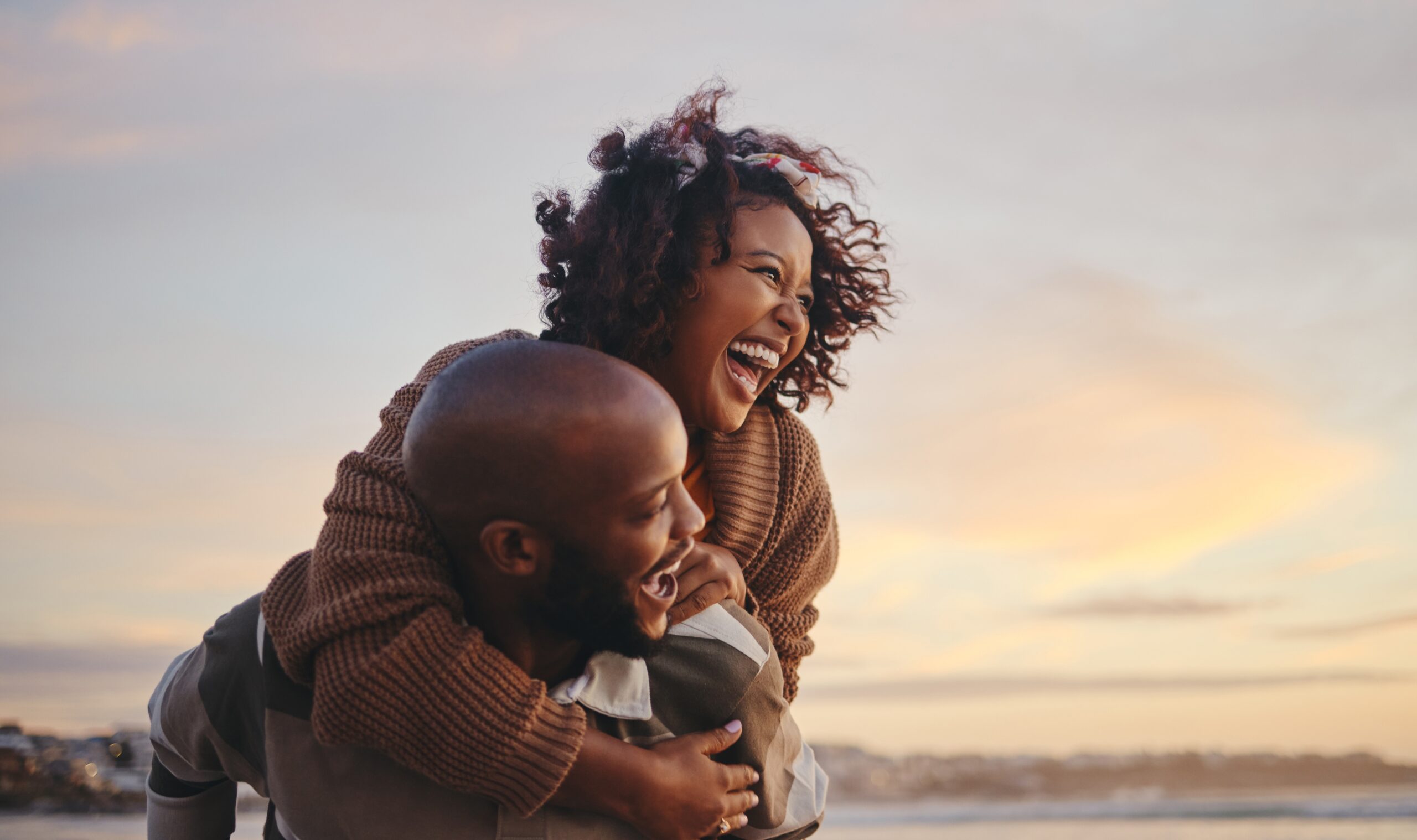 a man and woman laughing on the beach