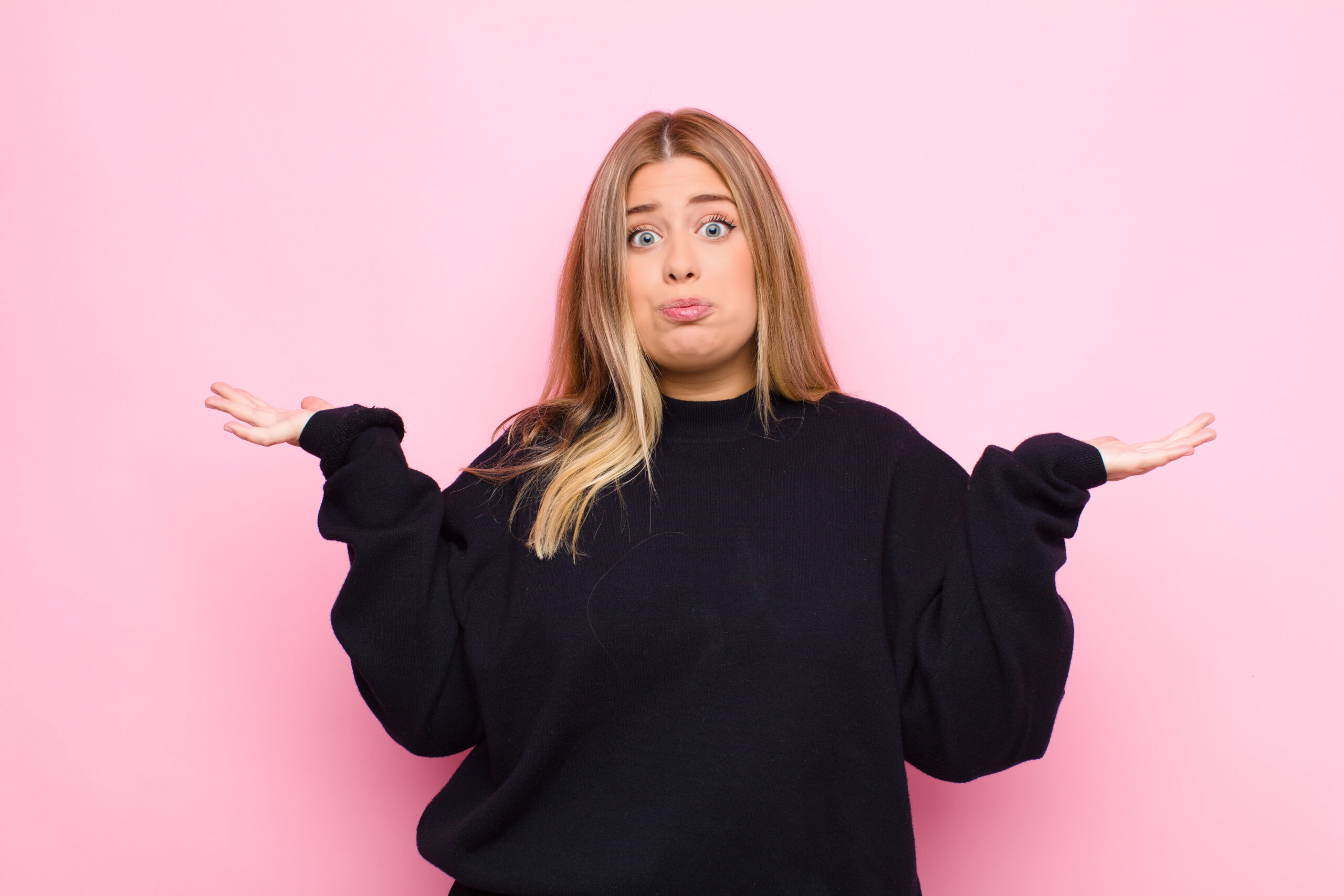 young blond woman shrugging her shoulders in not knowing something