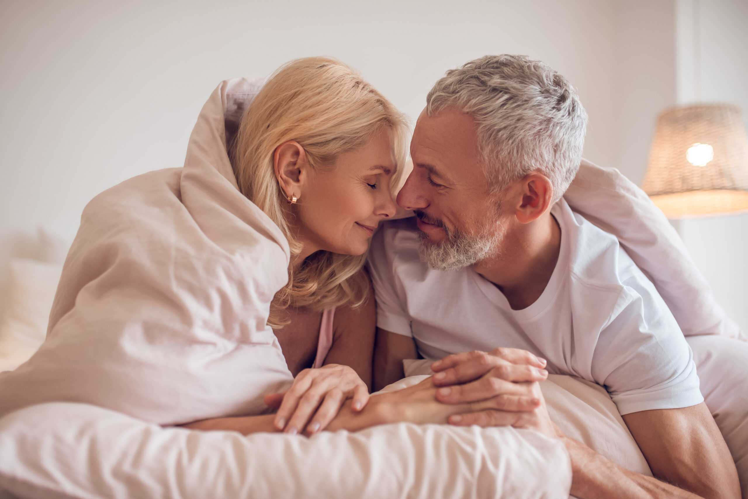 a happy morning with a middle aged couple having a romantic moment in the bedroom